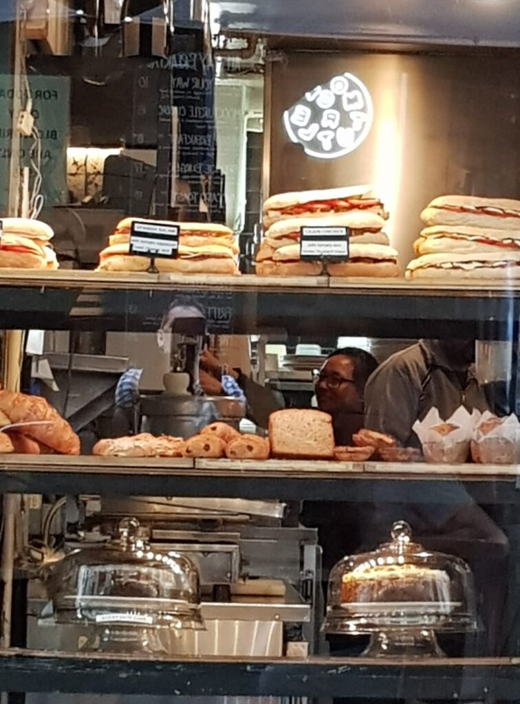 An image of a cafe staff member keeping the display window refreshed.